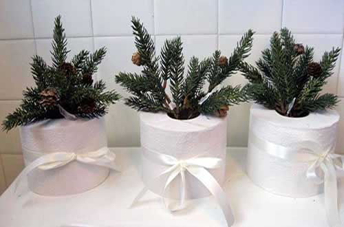 Rouleaux de papier toilette avec branches de pin et rubans blancs