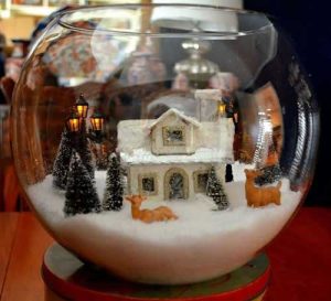 Bol en verre avec neige artificielle, maisons miniatures et pins